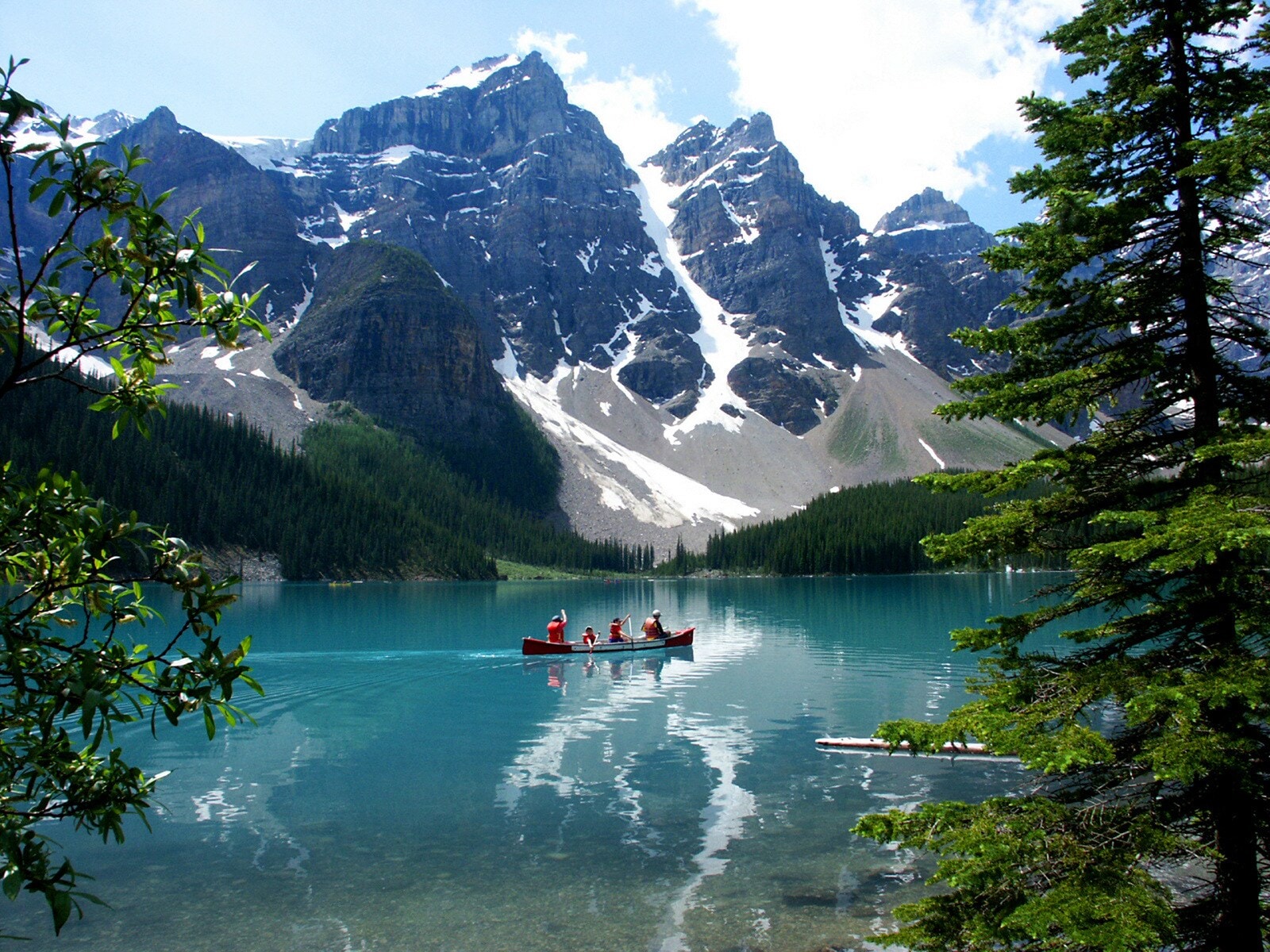 Ein Kanu auf dem Lake Moraine in Alberta vor der Kulisse der kanadischen Rocky Mountains Ein Kanu auf dem Lake Moraine in Alberta vor der Kulisse der kanadischen Rocky Mountains