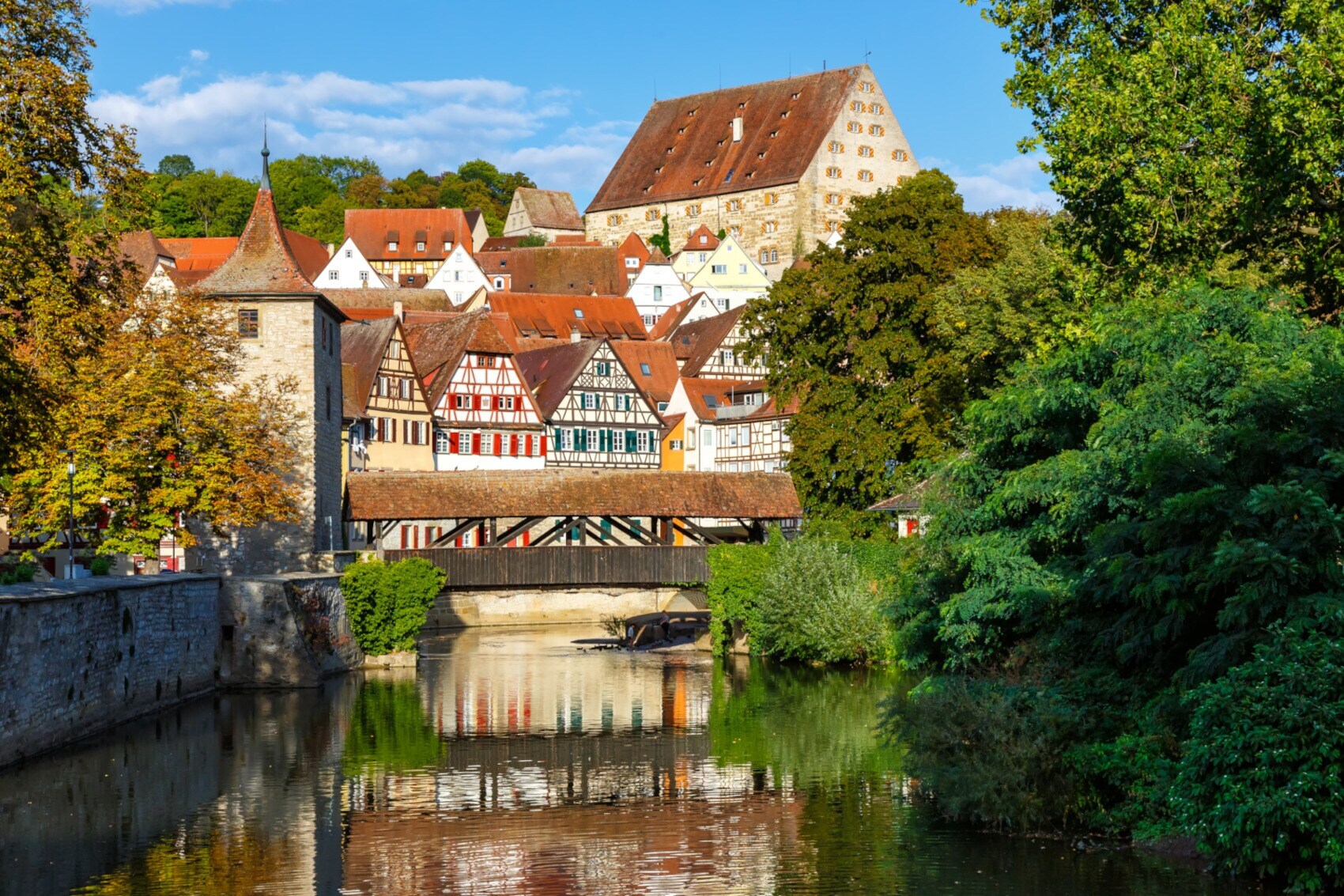 Fachwerkhäuser und Bäume an einem Fluss