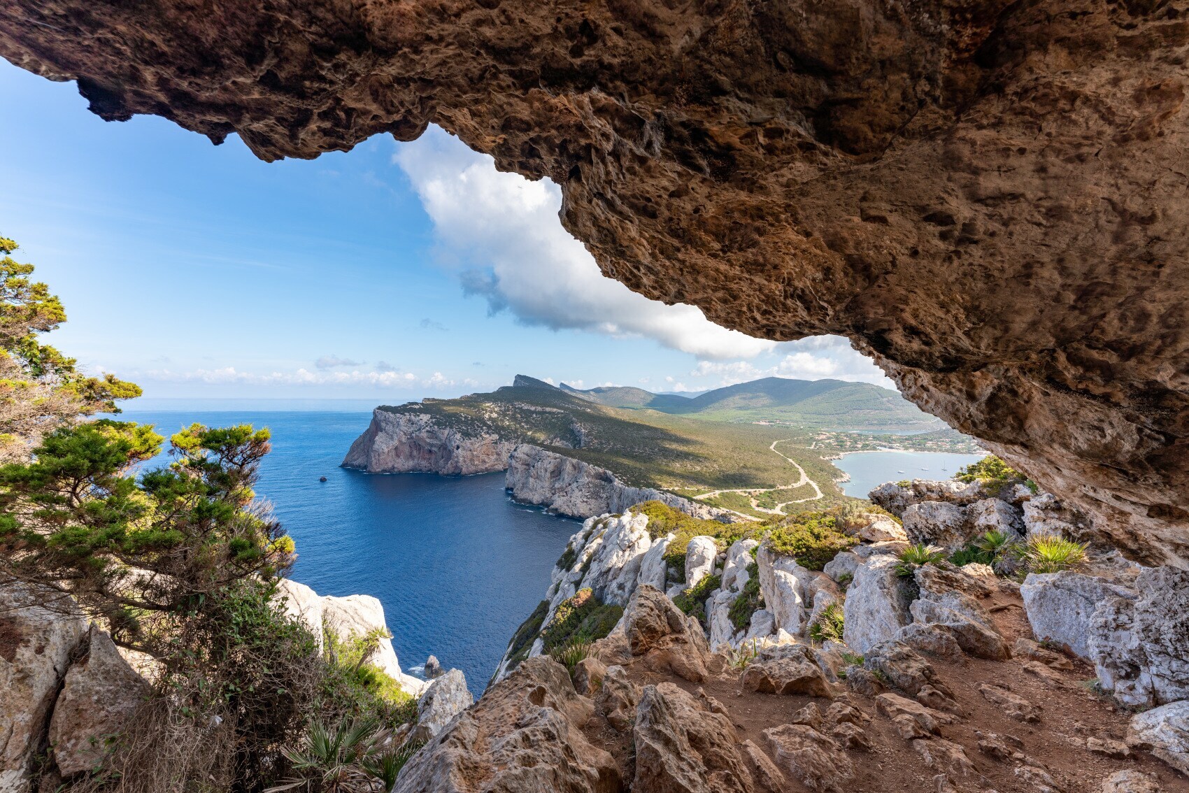Blick zwischen Felsen hindurch auf eine Landzunge Sardiniens