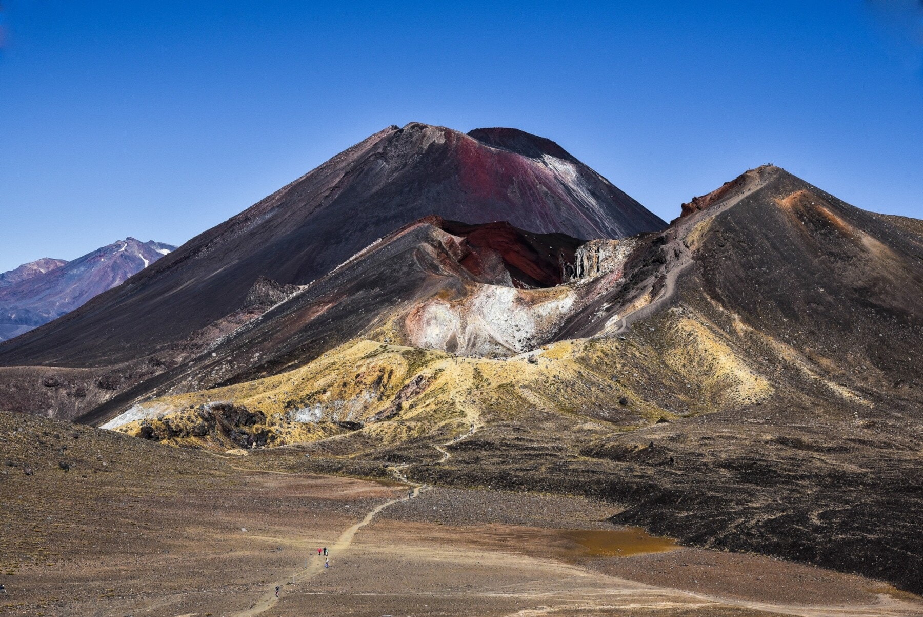 Ein dunkler Vulkan mit roten Farbverläufen in karger Landschaft Ein dunkler Vulkan mit roten Farbverläufen in karger Landschaft