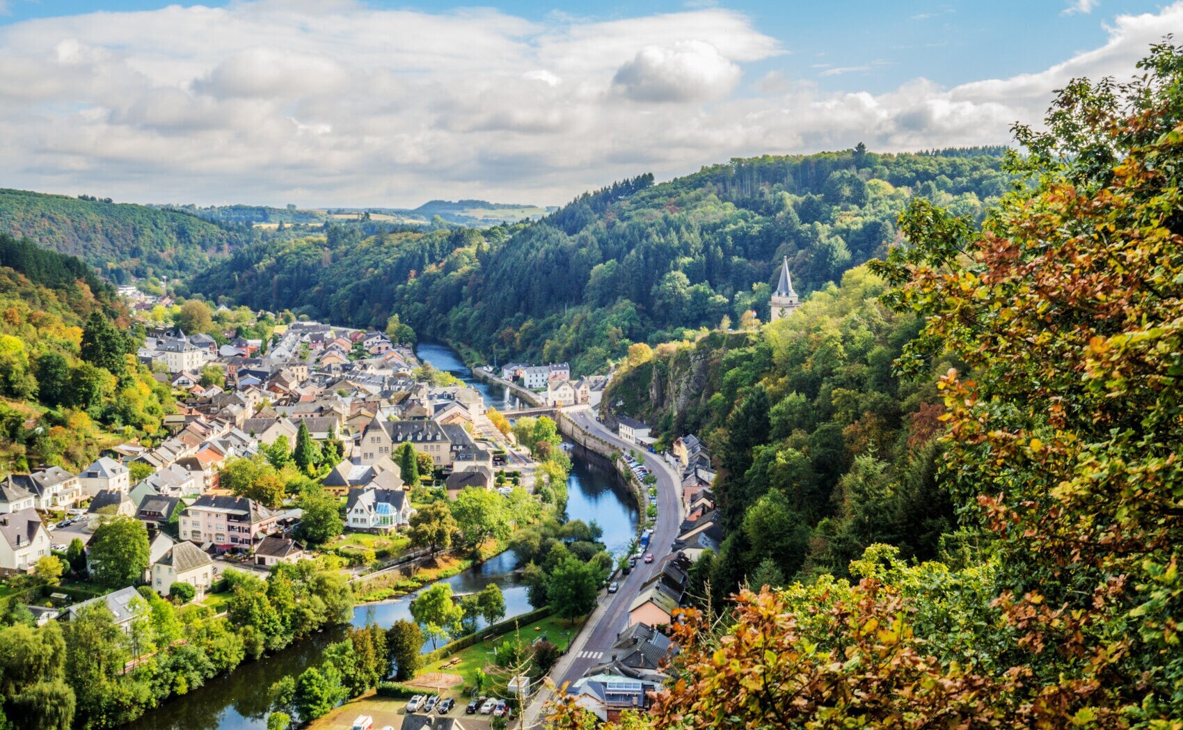 Ein Fluss fließt durch ein von Hügeln umgebenes Tal mit einer kleinen Stadt