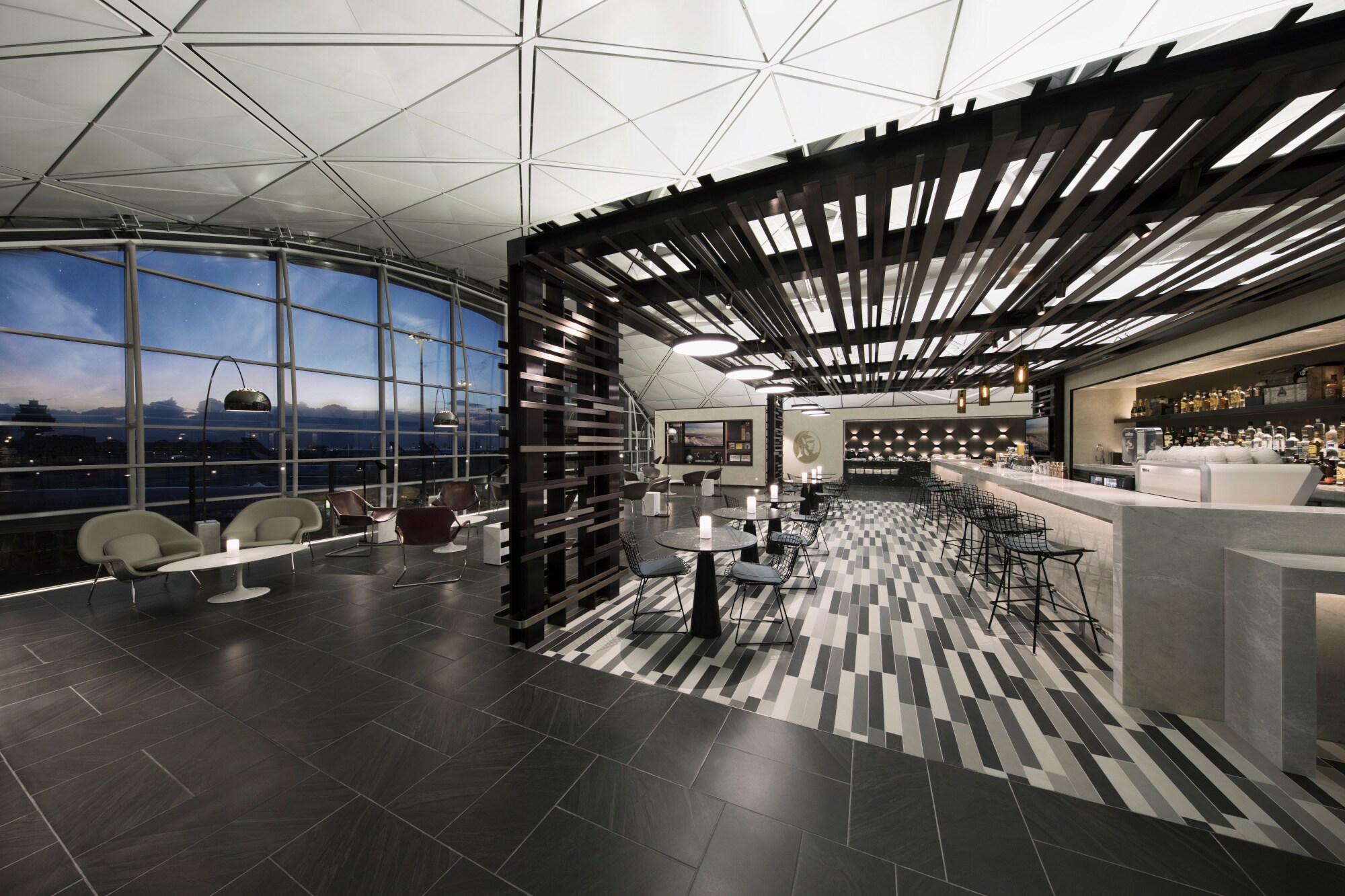 Große, moderne Flughafenlounge mit Bar und Panoramafenster mit Blick aufs Rollfeld