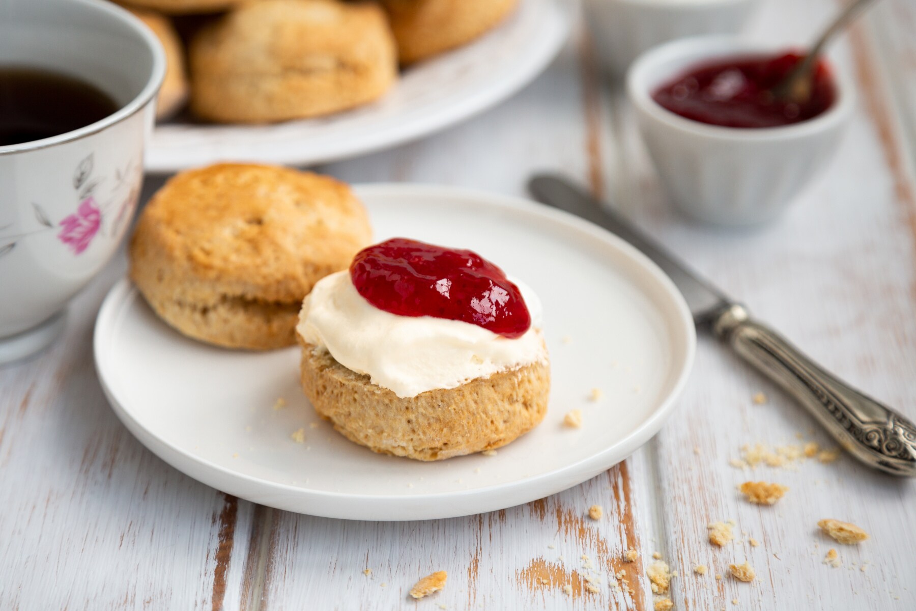 Nahaufnahme eines halbierten Scones mit Clotted Cream und Marmelade