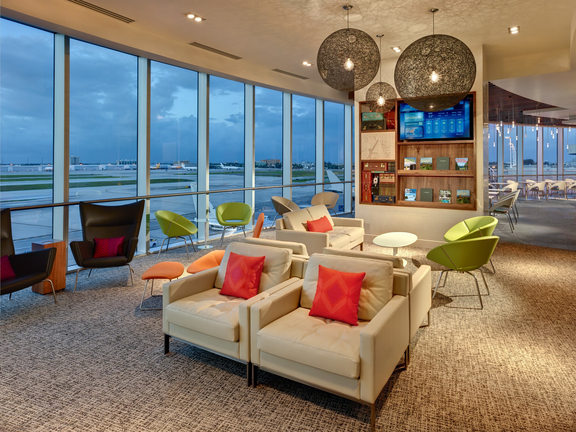 Moderne Flughafenlounge mit bodentiefen Panoramafenstern und Blick aufs Rollfeld.