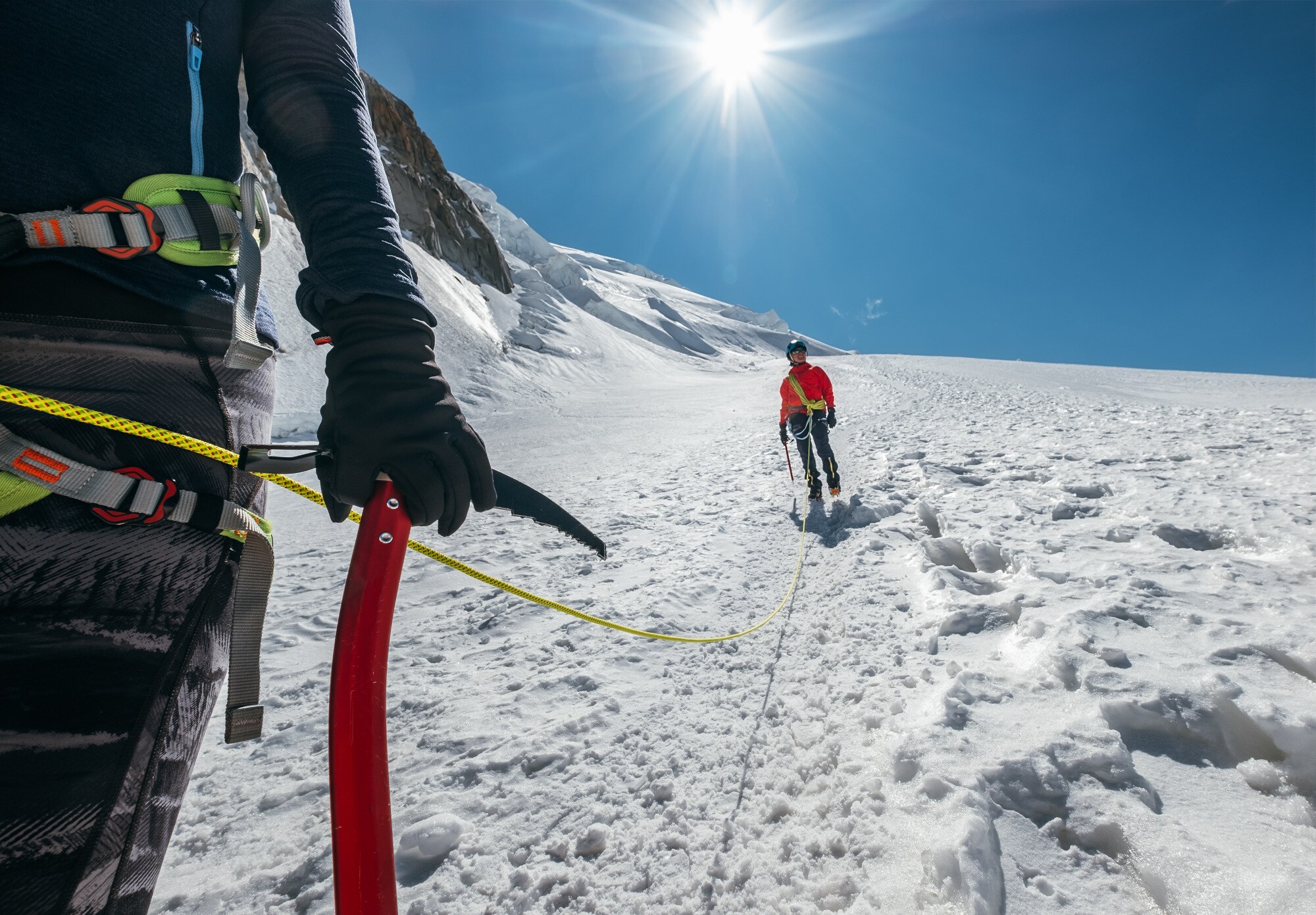 Zwei Personen mit Kletterausrüstung an einem schneebedeckten Berg