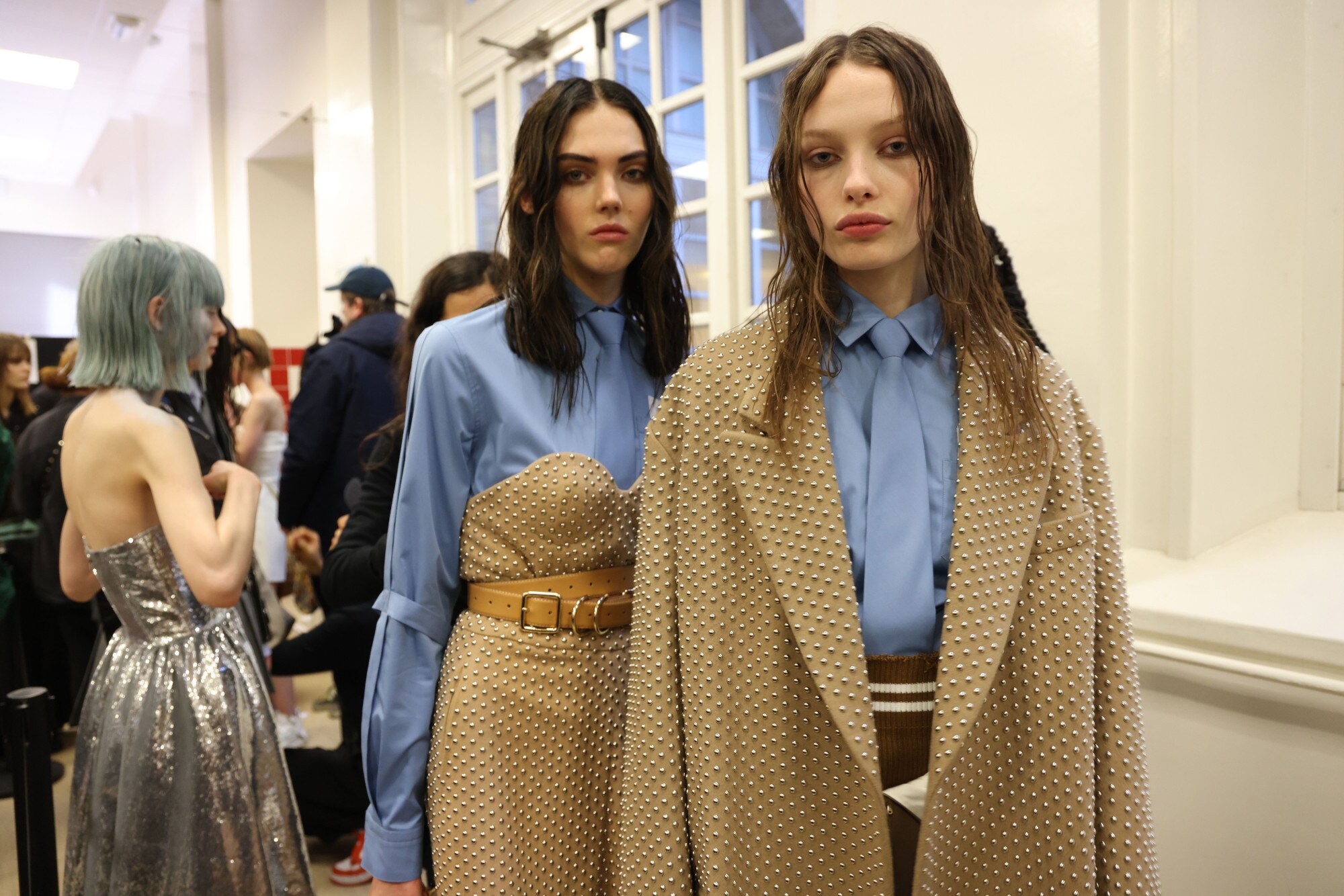 Zwei weibliche Models in eleganter Kleidung in der Farbkombination Beige und Hellblau im Backstage-Bereich einer Modenschau