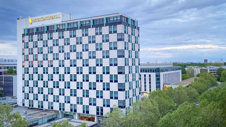 Außenansicht eines Hochhauses mit Schachbrettfassade und Intercontinental-Logotype in urbaner Umgebung.