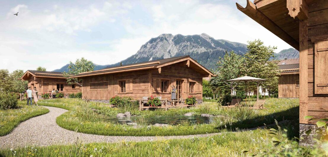 Ein traditionelles Holzhaus im Allgäu mit grüner Wiese und Bachlauf