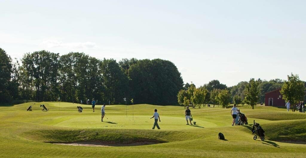 Golfer trainieren Abschläge auf einem Übungsareal mit Hindernissen