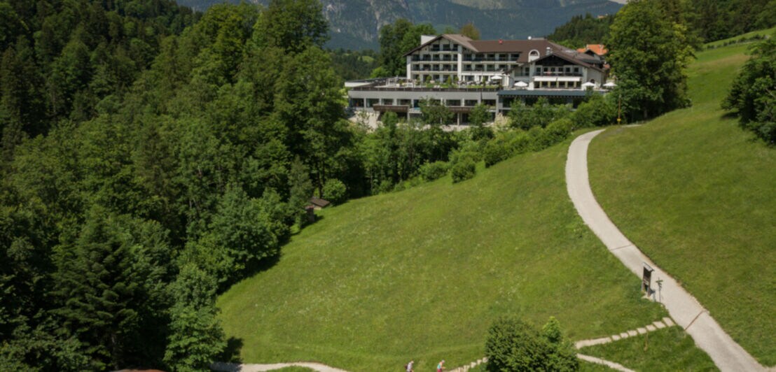 Ein großes Hotel liegt inmitten von Bergwiesen