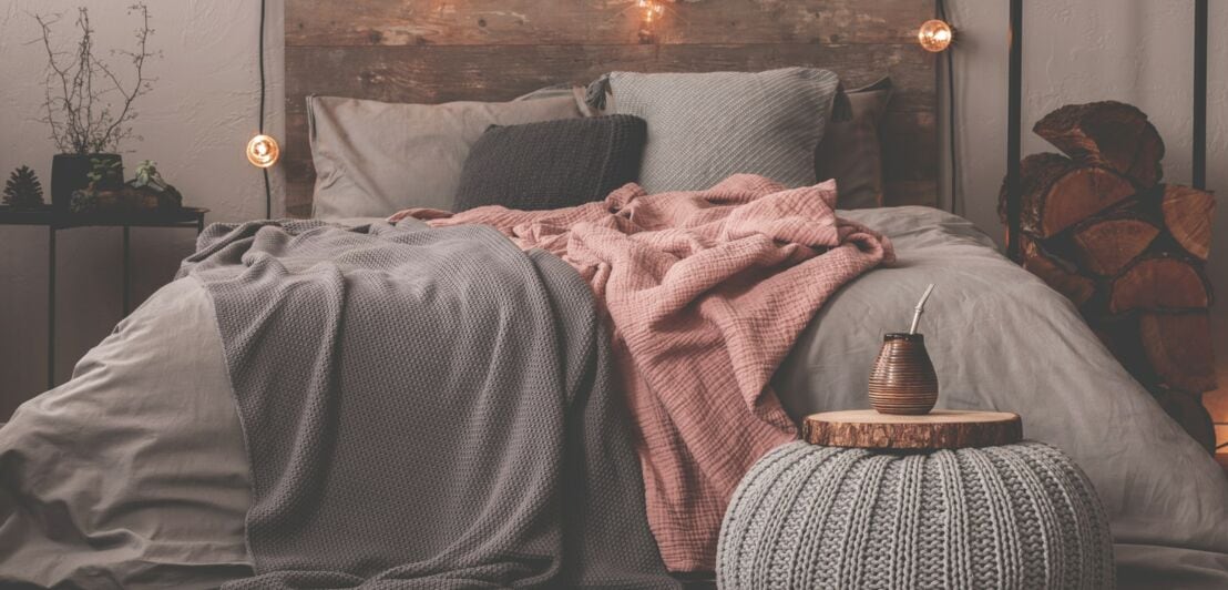 Ein Bett vor einer grau-beigen Wand