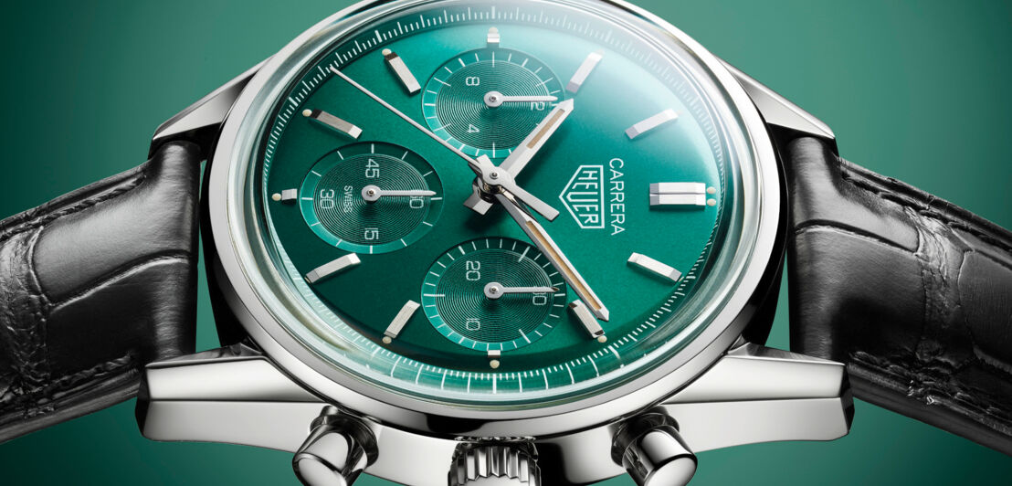 Eine Uhr die auf der Seite liegt mit grünem Zifferblatt