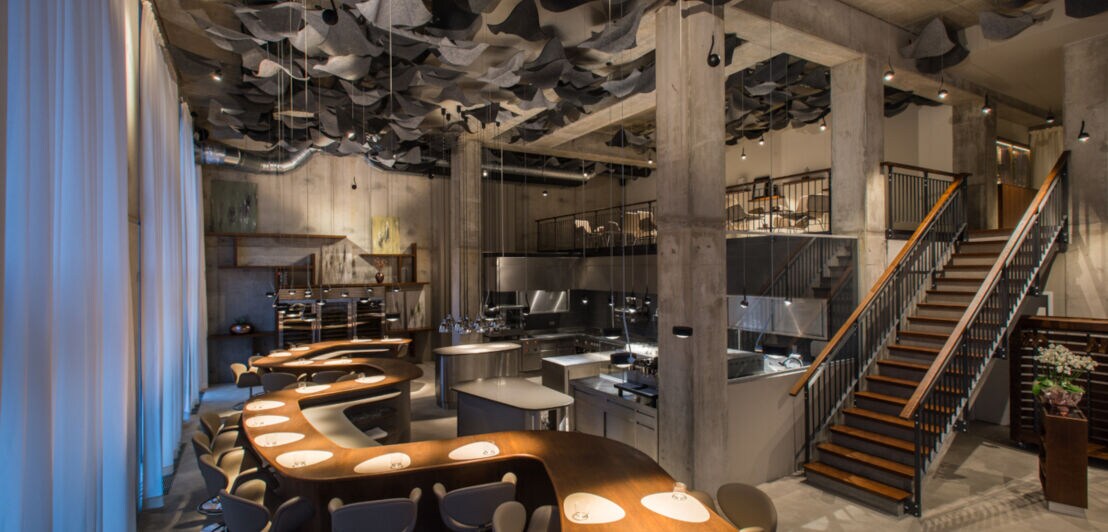 Ein modernes Restaurant im Industrie-Stil mit einem langen, wellenförmigen Tresen