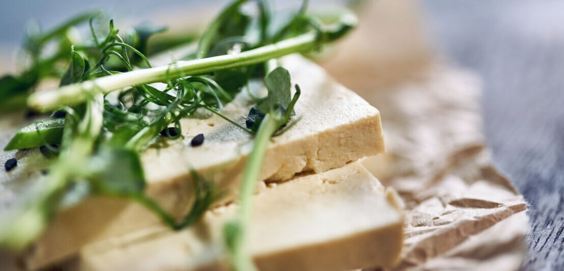 Tofu und Kräuter auf einem Brettchen