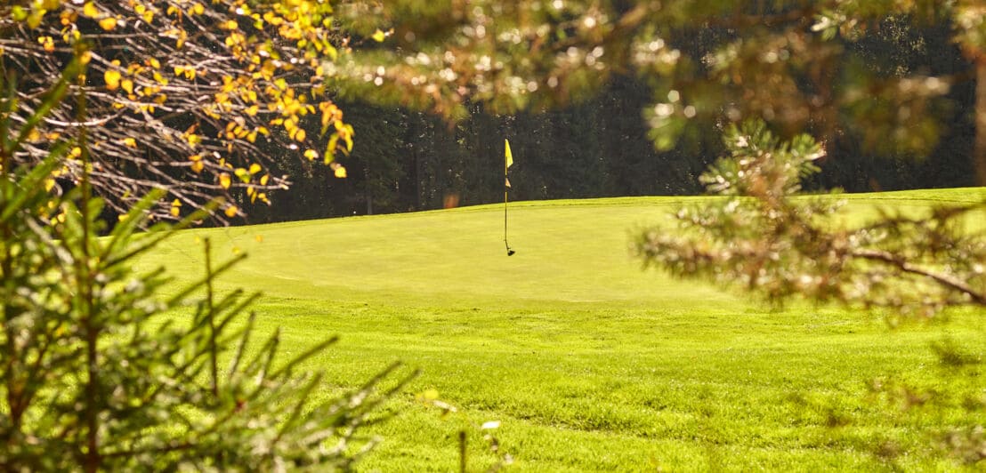 Ein Hügel mit gelber Fahne auf dem Golfplatz