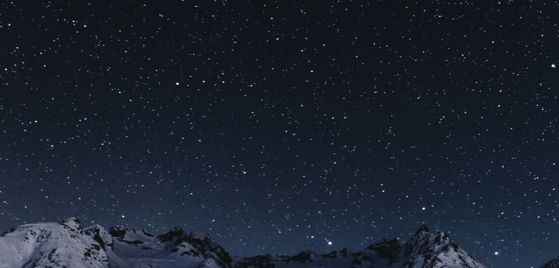 Sternenhimmel über Berggipfeln in einer klaren mondlosen Nacht