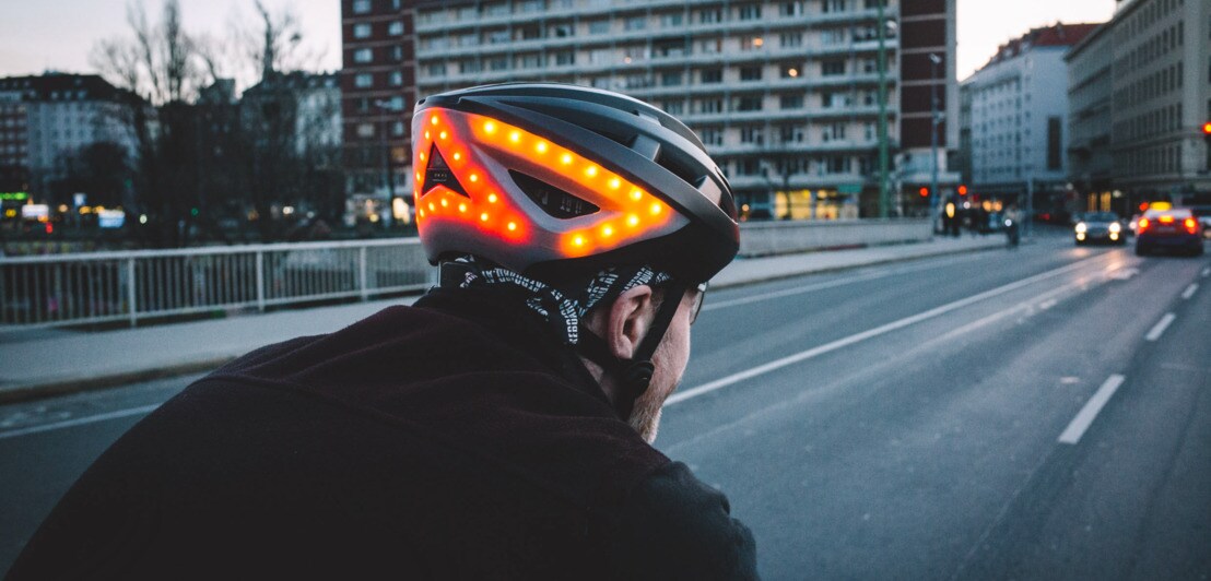 Ein Mann auf dem Fahrrad trägt einen Helm mit eingebauter Blinkerfunktion