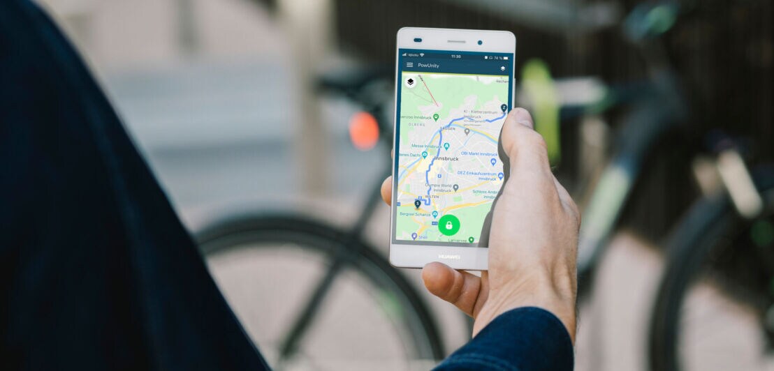 Ein Mann verfolgt die GPS-Daten seines Fahrrads auf seinem Smartphone