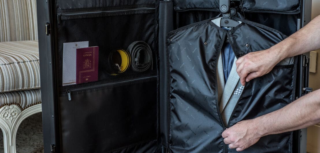 Ein stehender offener Koffer mit Jackets in Schutzhülle