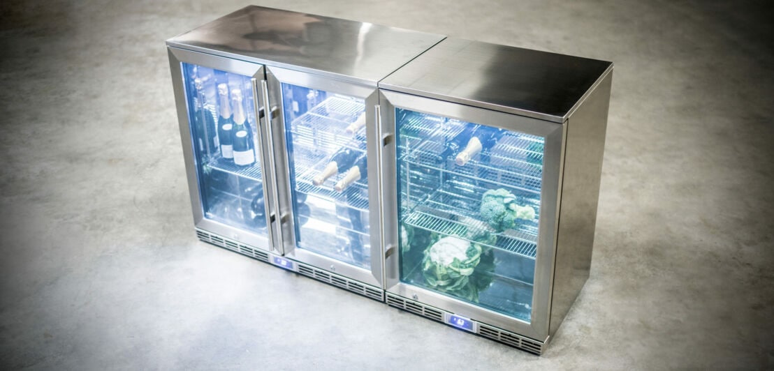 Ein Kühlschrank aus Edelstahl mit drei Glastüren