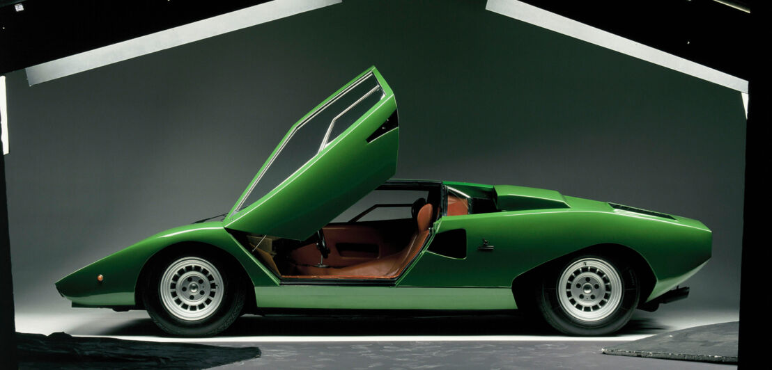 Seitenansicht eines grünen Lamborghini Countach LP400 mit geöffneten Türen in einem Fotostudio