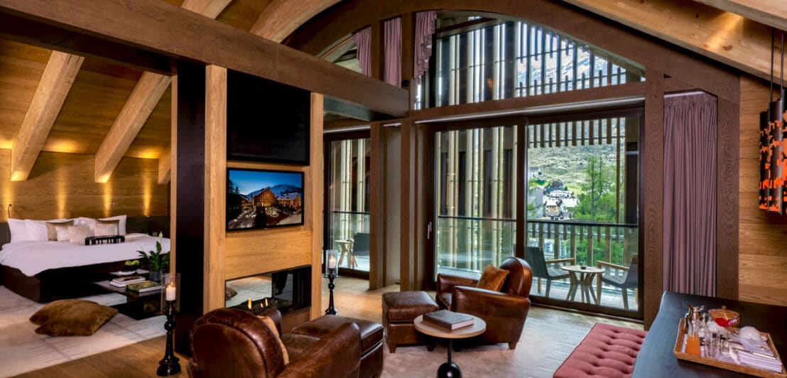 Innenraumaufnahme einer modernen Hotelsuite mit Terrasse und Blick in die Berge