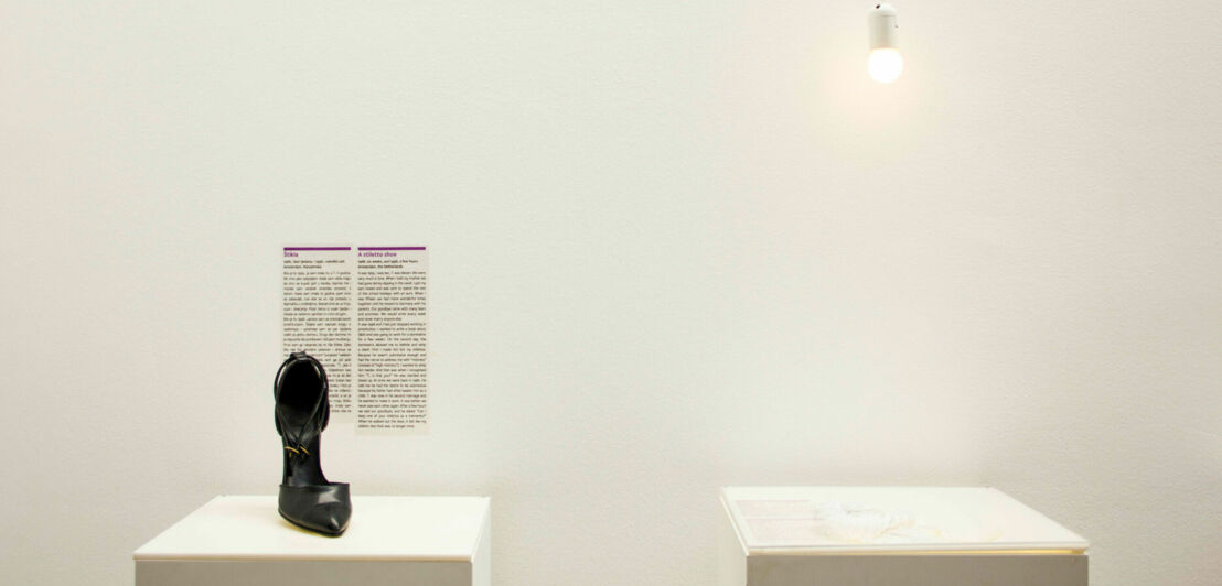 Ein schwarzer Damenpump steht auf einer Podest im Museum of Broken Relationships