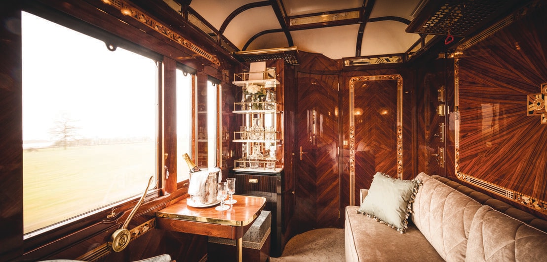 Luxuriöses, privates Zugabteil mit Panoramafenster und Champagner auf Tisch