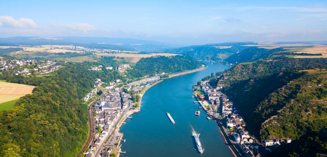 Panoramablick auf Rhein mit Ortschaften, die sich entlang der Ufer erstrecken, im Hintergrund Natur