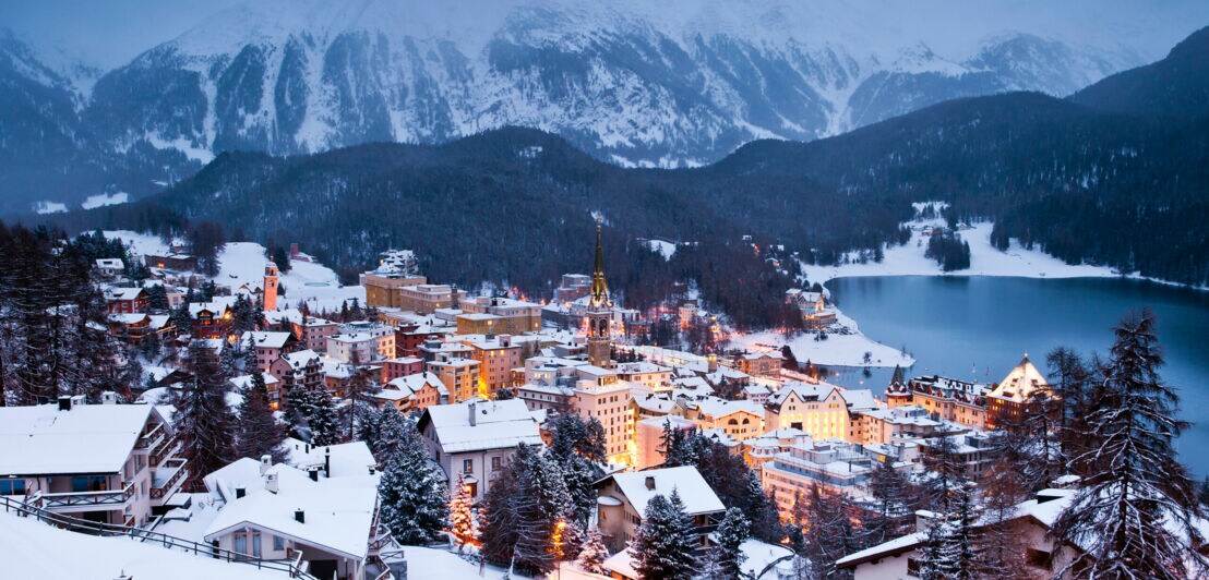 St. Moritz in der Abenddämmerung, die Stadt ist beleuchtet.