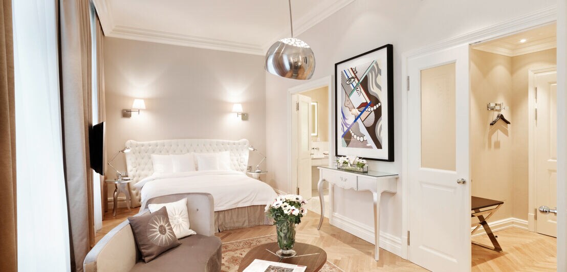 Eine helle, elegante Hotelsuite mit moderner Kunst an der Wand