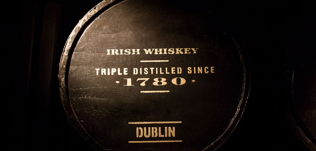 Ein Holzfass vor dunklem Hintergrund mit der Aufschrift Irish Whiskey Triple Distilled Since 1780 Dublin