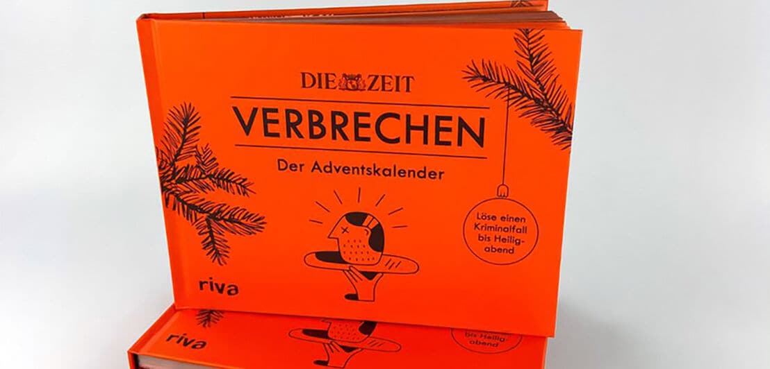Vorderansicht eines orangefarbenen Adventskalenders in Form eines aufgeklappten Buches