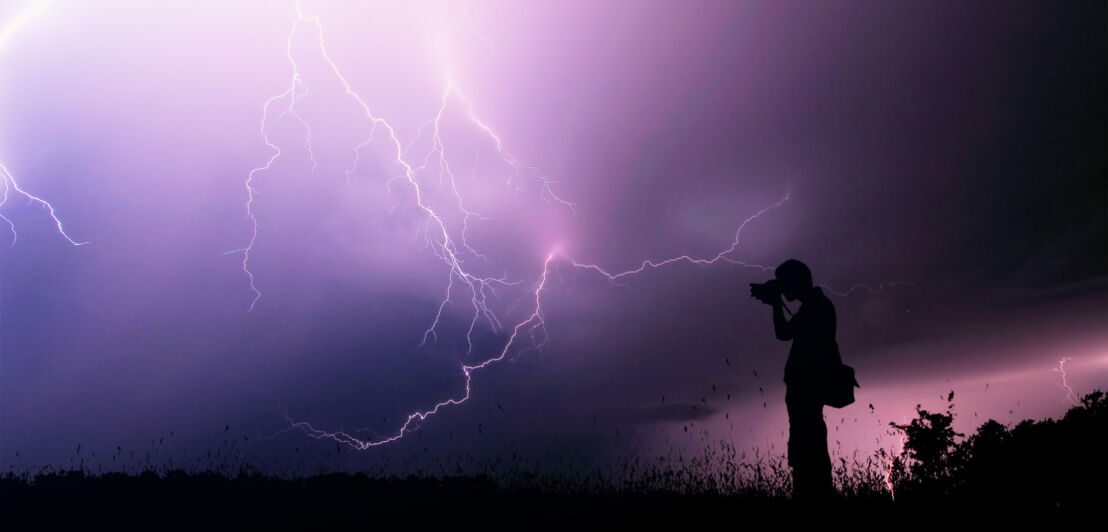 Ein Mann fotografiert ein Gewitter.