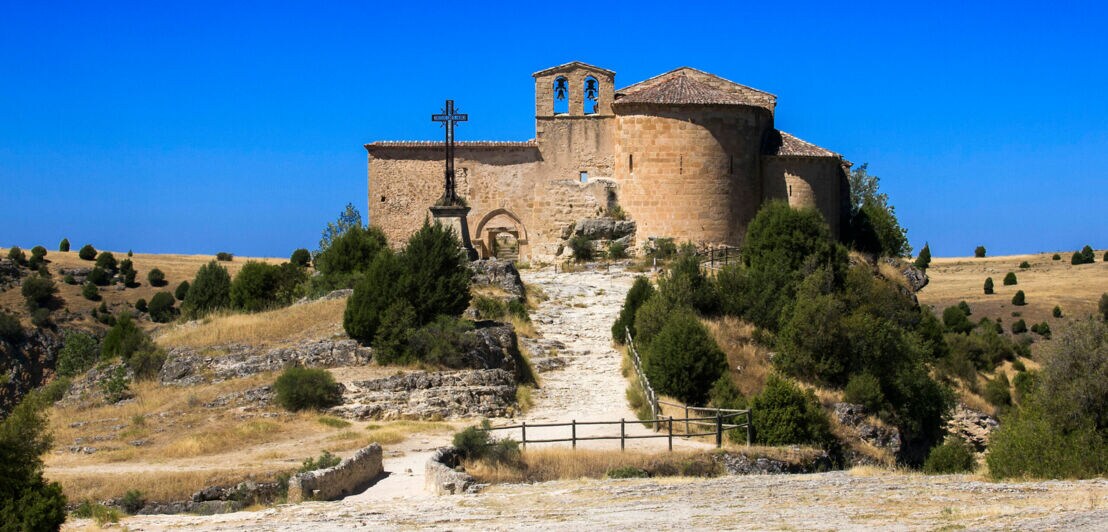 Kleines mittelalterliches Bauwerk mit Kapelle auf einer Anhöhe in mediterraner Landschaft
