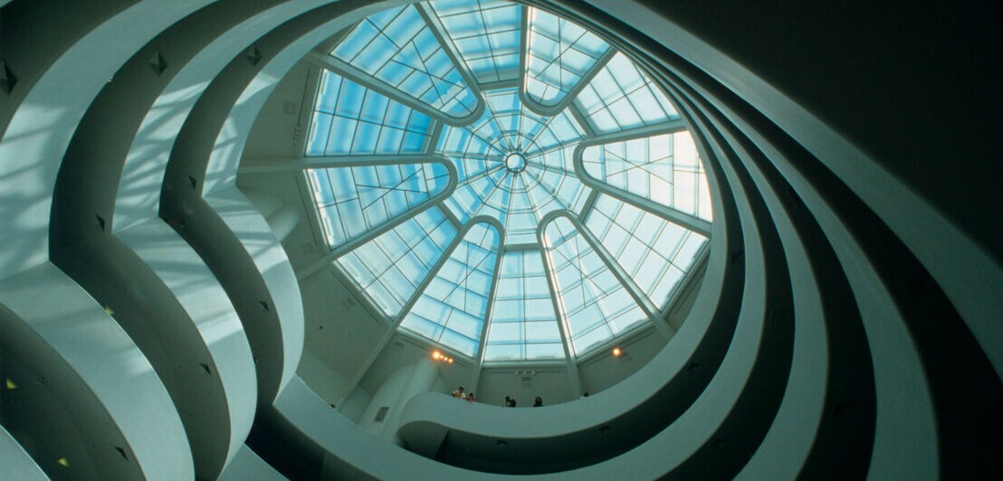 Innenaufnahme des spiralförmigen Baus des Guggenheim Museums aus der Froschperspektive mit Blick auf die Glaskuppel
