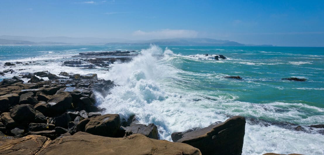 Hohe Wellen, die gegen Felsen peitschen