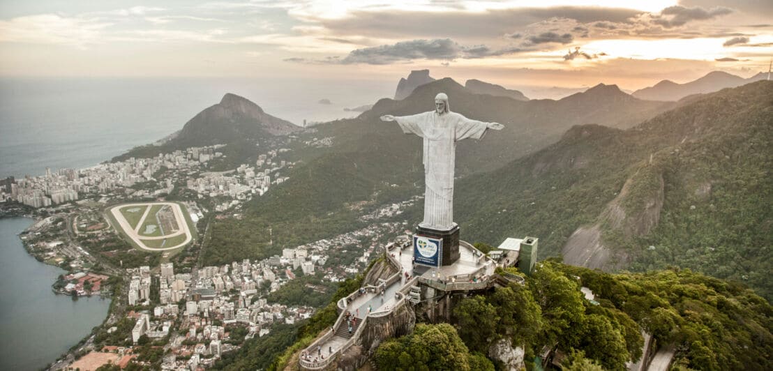 Luftaufnahme von Rio de Janeiro und Umgebung mit weißer Chrisstusstatue im Vordergrund