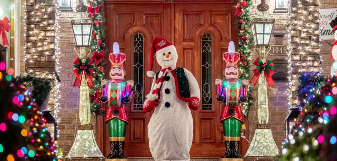 Ein weihnachtlich dekorierter und beleuchteter Hauseingang mit Schneemannfigur und Nussknackern