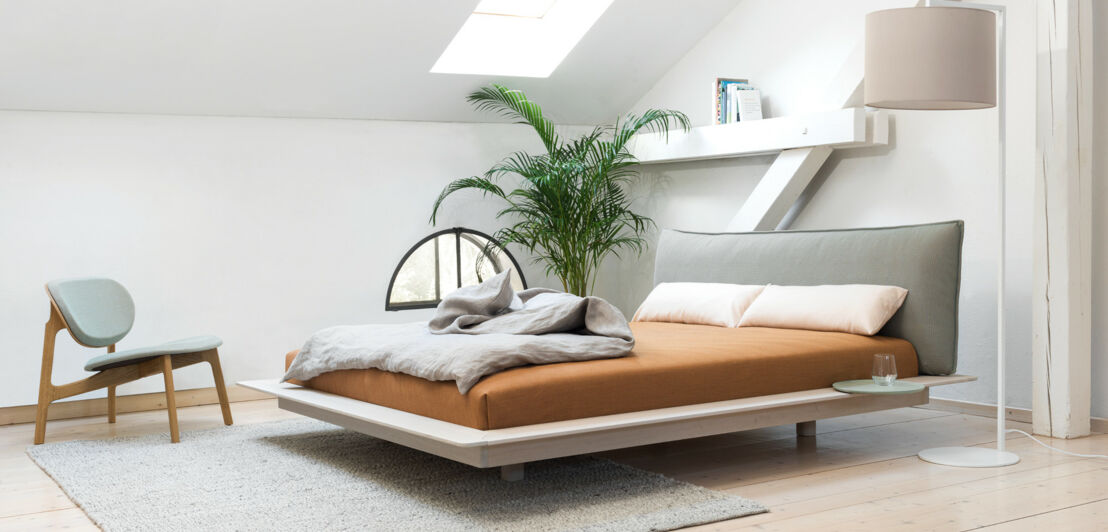 Helles, modernes Schlafzimmer mit einem großen Futonbett im minimalistischen Design