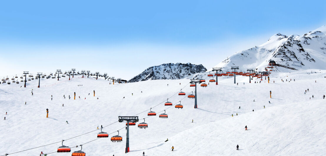 Skifahrer, Sessellifte, Schnee und Berge