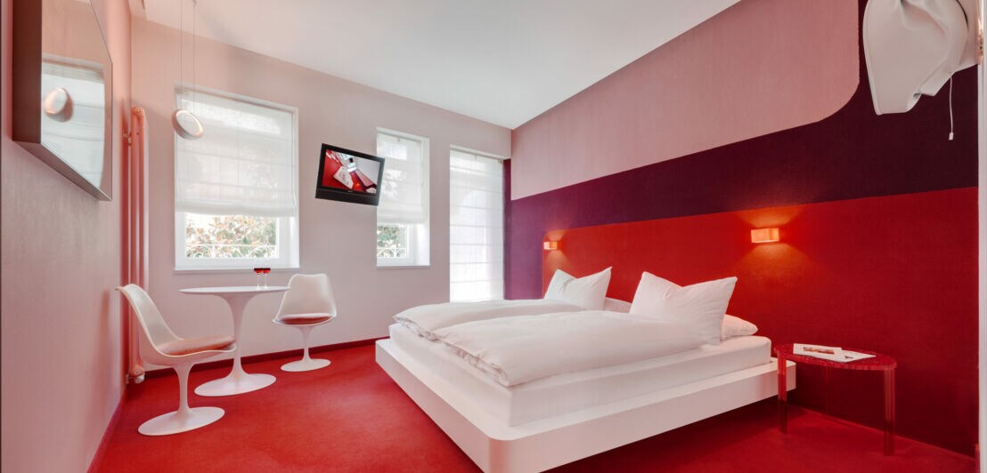 Innenansicht eines Hotelzimmers mit rotem Teppich
