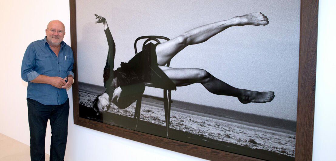 Fotograf Peter Lindbergh vor einem seiner Bilder bei einer Ausstellung