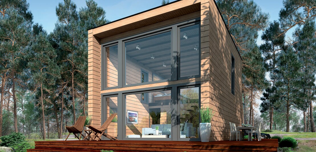 Ein modernes Blockhaus mit bodentiefer Glasfront und Terrasse im Wald
