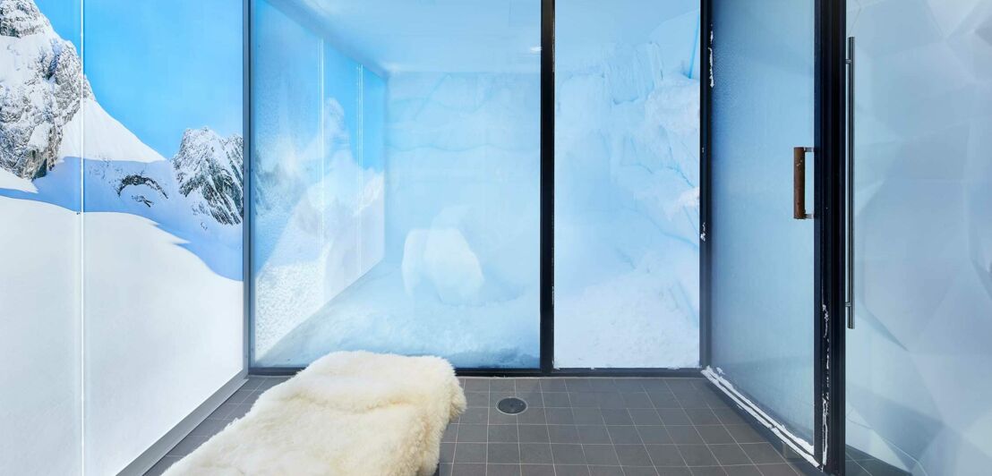 Eine Eiskammer mit Glastüren und einem beleuchteten Wandmotiv mit Schneelandschaft