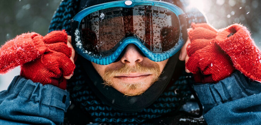 Ein Skiläufer mit Brille und Handschuhen.