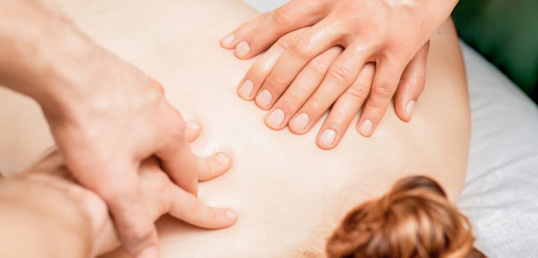 Eine Frau bekommt eine Vier-Hände-Massage