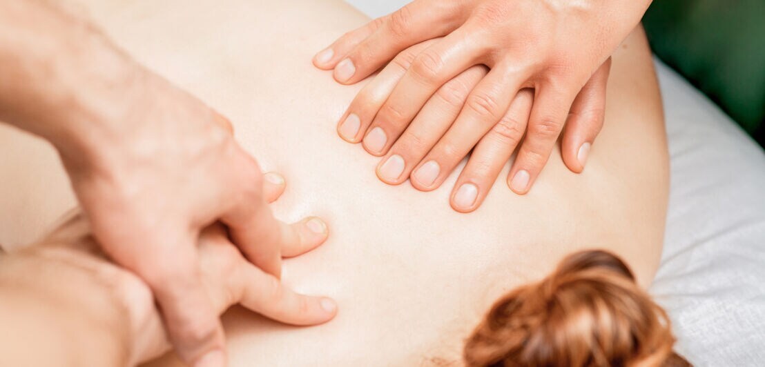 Eine Frau bekommt eine Vier-Hände-Massage