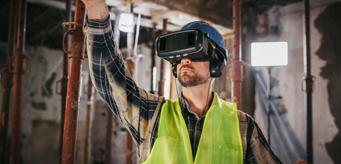 Ein Mann arbeitet auf einer Baustelle mit einer VR-Brille