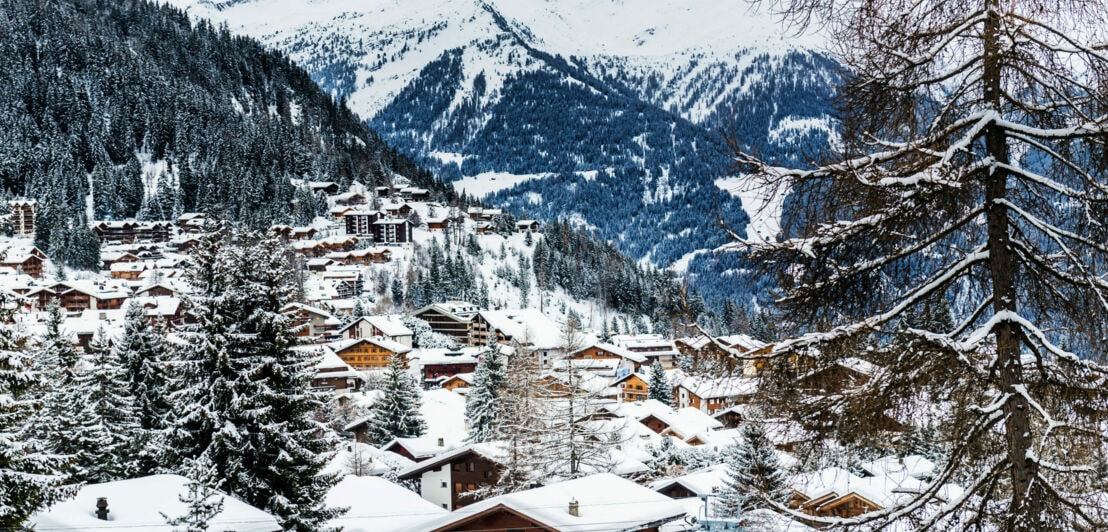 Eine verschneite kleine Stadt vor einer Bergkulisse
